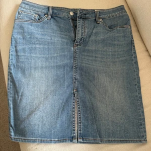 Jeanskjol från Crocker - Klassisk blå jeanskjol från Crocker i rak modell med femficksdesign och knapp- samt dragkedja framtill. 