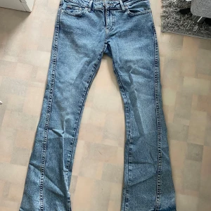 Blå jeansbyxor från Perfect Jeans - Säljer ett par klassiska blå jeansbyxor från Perfect Jeans med snygga kontrastsömmar och broderade bakfickor. Byxorna har normal passform och utsvängdaben, perfekt för en avslappnad stil.