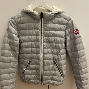 Ljusgrå dunjacka från Colmar - Säljer en (ljusgrå/lite toner av mintgrön/ljusblå toner) dunjacka från Colmar, har en vit målar fläck på huvan annars fint skick! Nypris ca 2000