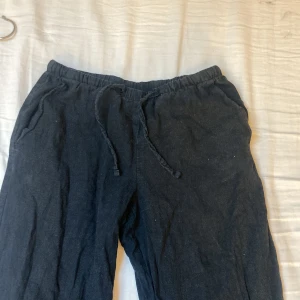 TVÅ PAR LINNEBYXOR - Luftiga, vita linnebyxor med tunna grå ränder och elastisk midja med snörning.                       Svarta lågmidjade linnebyxor men elastisk midja.                                                                 Säljer för 70kr för båda.De svarta har ett pyttelitet hål framtill men det är inget som märks.                                                                ⚠️OBS SÄLJER BILLIGT EFTERSOM ATT DE SVARA HAR ETT PYTTELITET HÅN FRAMTILL,KOLLA BILD 4!⚠️DE GRÅA HAR EN LITEN GRÄSFLÄCK⚠️