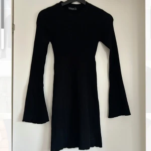 Svart klänning ribbad - Svart ribbad klänning från stradivarius, använd fåtal gånger men finns däremot ett hål vid halsen, går att sy ihop. Strl XS. Passar till fest men även som vardagsklänning.