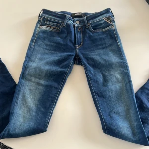 Blå Replay Hyperflex jeans - Säljer ett par blå Replay Hyperflex jeans i modellen Luz. Jeansen har klassisk femficksdesign, normal passform och snygga slitningar framtill. Stretchigt material för extra komfort. Nypris: 1700 och mitt pris: 470 kr. Perfekta till vardags och passar till det mesta. Skriv bara vid minsta fråga, priset kan diskuteras!