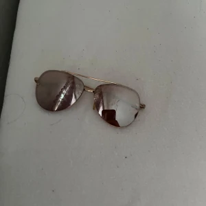 Guldiga pilotbågar med spegelglas - Snygga solglasögon i klassisk pilotmodell med tunna guldiga metallbågar och spegelglas. Perfekta för att lyfta din stil med en tidlös och cool look.