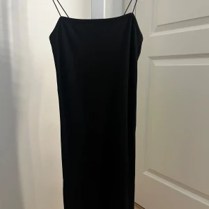 Svart fodralklänning med smala axelband från NA-KD - En stilren svart fodralklänning från NA-KD med smala axelband och rak passform. Perfekt för dig som gillar minimalistisk stil och vill ha något som passar till allt!!🌺