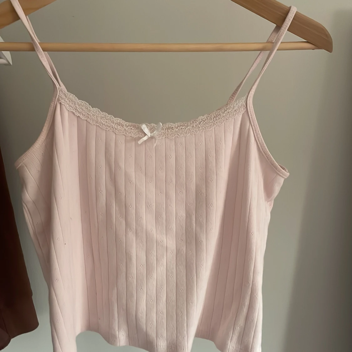 Ljusrosa ribbad linnetopp med spetsdetaljer