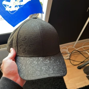 Sixites keps   - Snygg svart Sixties keps med diskret mönster. Köpt på Kungsgatan 67 i Göteborg och är helt oanvänd. Perfekt för en stilren look, justerbar passform för att sitta bekvämt på huvudet. Ord pris 199kr mitt pris 100kr🫡😁