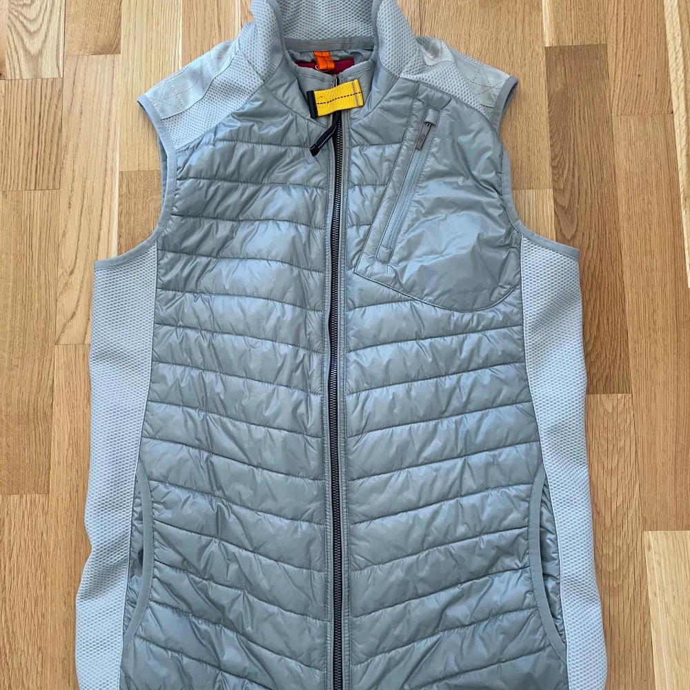 Snygg och funktionell grå dunväst från Parajumpers. Västen är i storlek Y-L som motsvarar S och den är i 9.5-10 skick och västen har inga hål eller slitningar och den är köpt från parajumper. och knappt använd, pris kan diskuteras. Nypris 2.700 kr. Takit.