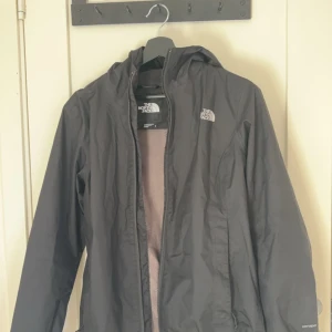 Svart vindjacka från The North Face - Säljer en svart vindjacka från The North Face med huva och dragkedja. Storleken på jackan är M men den sitter mer som S