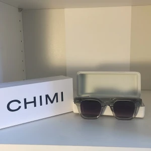 Transparenta solglasögon från CHIMI - Snygga transparenta solglasögon från CHIMI med en modern fyrkantig design. De har mörka linser som ger ett coolt uttryck och skyddar mot solen. Perfekta för en stilren look.priset kan diskuteras 