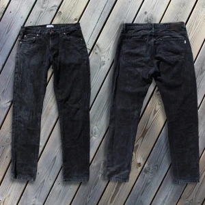 Svarta jeans från Woodbird - Snygga svarta jeans från Woodbird i modellen Doc Nighth Jeans. De har en klassisk femficksdesign med knapp och dragkedja framtill. Perfekta för en stilren look. | Nypris 1 099 kr