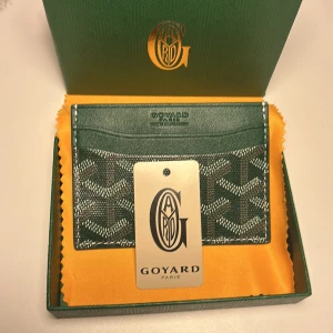 Snygg Grön plånbok från Goyar - Säljer en elegant grön plånbok med det ikoniska mönstret.💯 Plånboken har flera fack för kort och är perfekt för den stilmedvetna. Kommer i originalförpackning med etikett. Skriv till mig vid frågor och funderingar så svarar jag så fort jag kan😊