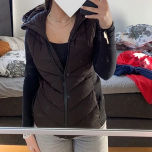 Svart dunväst från Zara - Snygg svart dunväst från Zara med dragkedja framtill. Perfekt för lager-på-lager under kyliga dagar. Västen har en stilren design och är lätt att matcha med olika outfits. Västen är i mycket bra skick har använt den 6-7 gånger!