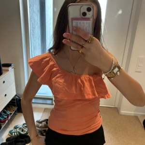 Volangtopp  - Säljer en söt persikofärgad off-shoulder topp med volangdetaljer. Perfekt för sommardagar! Toppen går att använda på flera olika sett !💞lappen är avklippt men den är ifrån Gina tricot i storlek S 💞 inga defekter 💞