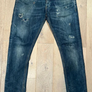 Blå jeans från Dondup - Snygga blå jeans från Dondup med slitna detaljer för en trendig look. De har en klassisk femficksdesign och en knappgylf. Perfekta för en avslappnad stil.