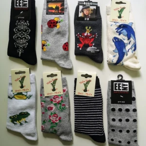 8 Par Färgglada Damstrumpor Med Olika Mönster - Ett set med åtta par strumpor i olika färger och mönster. Inkluderar motiv som nyckelpigor, grodor, blommor och ränder. Tillverkade av bomull, polyamid och elastan för komfort och hållbarhet. Perfekta för att liva upp vardagslooken!