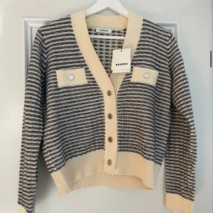 Randig kofta från Sandro - Snygg randig kofta från Sandro i beige och blått. Strl: 0, nypris 2900kr! Aldrig använd. 