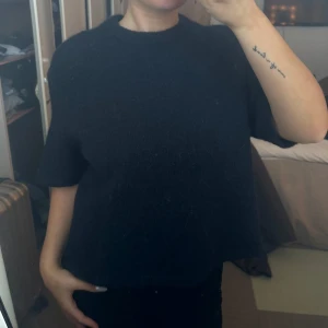 Mörkblå tröja med korta ärmar - Säljer en stilren mörkblå tröja med korta ärmar. Perfekt för en avslappnad look. Tröjan har en enkel design och är lätt att matcha med olika outfits.