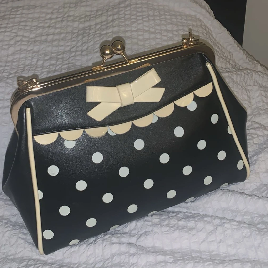 Svart handväska med prickar och rosett