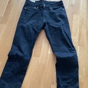 Svarta jeansbyxor - Snygga svarta jeansbyxor med klassisk femficksdesign och knappgylf. Perfekta för en snygg stil.