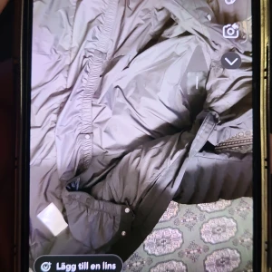 Svart dunjacka från Peak Performance - Säljer en svart dunjacka från Peak Performance. Jackan har en lång design med huva och dragkedja framtill. Perfekt för kyliga dagar.