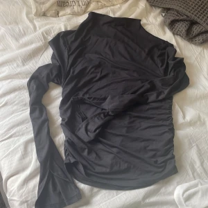 Mörkgrå långärmad från Gina Tricot - Svart långärmad från Gina Tricot i mjukt bomullsliknande material. Modellen är kort med åtsittande passform och har snygg rynkdetalj på sidan samt hög hals. Perfekt för dig som gillar stilrena och enkla plagg med en twist. Aldrig använd bara testad💞Skriv om ni har några frågor eller något och priset kan alltid diskuteras!!