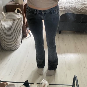 Svarta bootcut jeans med låg midja - Säljer ett par svarta bootcut jeans med låg midja från Ginatricot. Jeansen har klassisk femficksdesign och är i stretchigt denimtyg som sitter snyggt över höfterna och låren innan de släpper ut vid bensluten. Endast använd 1 gång!