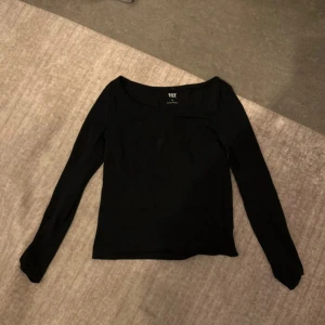 Svart långärmad tröja från 157 - En stilren svart långärmad tröja från 157 med rund halsringning. Tillverkad i mjuk bomullsmix med lite stretch för en bekväm passform. Perfekt att matcha med jeans eller kjol för en enkel och snygg look.