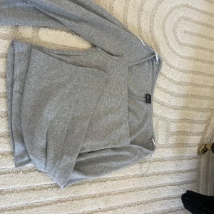Grå tröja med vida armar - Mjuk och söt tröja med vida armar. Perfekt för chill dagar eller när du vill ha en enkel och clean look. Långärmad och i skönt bomullsmaterial.