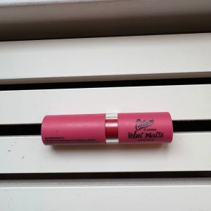 Glam of Sweden Velvet Matte läppstift - Snyggt läppstift i en matt finish från Glam of Sweden. Hylsan är rosa med silvrig detalj och själva läppstiftet har en djup röd nyans. Perfekt för dig som gillar en klassisk look med sammetslen känsla på läpparna.
