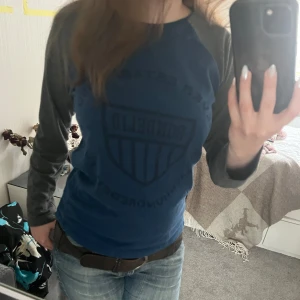 Långärmad tröja  - En långärmad tröja från Bondelid med blå framsida och rygg samt grå ärmar. Tröjan har tryckt logga och text på framsidan. Passar som S. Skriv vid mått och frågor! 🫶💗