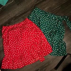2-pack kjolar - Två stycken omlottkjolar med vita blommor och volangdetaljer. Kjolarna har en knytning i sidan som ger en fin passform. Från Only i stormen XS