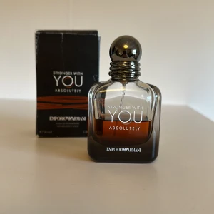 Stronger With You Absolutely. Av Emporio Armani - Cirka 50%(hälften) kvar.                                               Väldigt öppen för diskussion av pris!                      Emporio Armani Stronger With You Absolutely är en parfym i en stilren, mörkbrun glasflaska med rundad form och metallisk silverkork. Doften är intensiv och modern, perfekt för dig som vill sticka ut med en elegant och maskulin touch under både sommaren och vintern. Levereras med originalkartong.