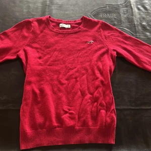 Röd stickad tröja från Hollister - Snygg röd stickad tröja från Hollister med rund halsringning och diskret logga broderad på bröstet. Är nästan inte alls använd , den är fin men jag måste få bort några grejer. 