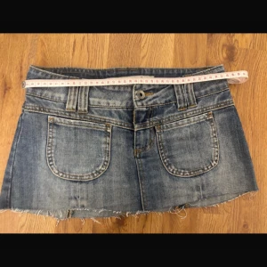Jeanskjol från Only - Snygg blå jeanskjol från Only med rå, fransig kant och slitna detaljer. Klassisk femficksmodell med  broderade bakfickor, varav en har en svart fågel. Perfekt för dig som gillar en cool och avslappnad stil.💗💗
