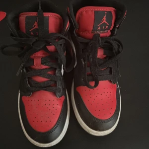Nike Air Jordan 1  mid svart/röd/vit -  Säljer mina Jordan 1 Mid i klassiska svart, röd och vita färger. Jag använder dem aldrig och de är tyvärr för små för mig. Har max använt dem 2 gånger, så skicket är riktigt bra – nästan som nya!  Storlek: 36 Skick: Nästan nya köpta för 1399kr   