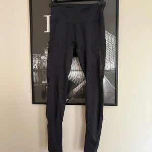 Svarta ridbyxor s från Uhip - Snygga, svarta, helskodda  ridbyxor från Uhip. Ett pytte litet hål längre ner på benet men annars andvända fem gånger!