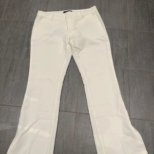 Vita bootcut kostymbyxor Bik Bok - Snygga vita kostymbyxor från Bik Bok med bootcut-modell.  Perfekta för en clean och fräsch look. Materialet känns mjukt och har en lätt stretch. Endast använd ca 1-2 gånger