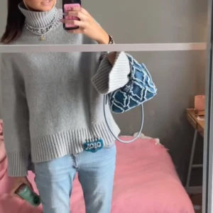 Grå polotröja - Supermysig grå stickad polotröja med bred ribbad kant nertill och på ärmsluten. Tröjan har oversized passform, höga slitsar vid ärmarna och en rejäl polokrage. Perfekt för lager-på-lager och chill stil.