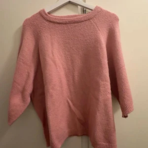 Rosa stickad tröja - Mysig rosa stickad tröja och bred halsringning. Tröjan har kvart ärmar och ribbade muddar vid ärmslut och nederkant. Perfekt för dig som gillar en chill och avslappnad stil.