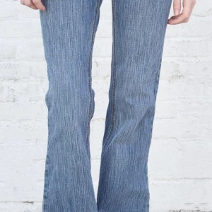 Blå bootcut jeans - Lågmidjade bootcut jeans från brandy melville. Randig tvätt. Något slitna längst ner.