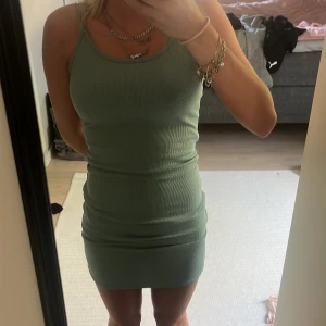 Grön kortklänning  - Säljer en tight, ribbad grön klänning som är köpt i spanien med smala axelband och rund halsringning. Klänningen är kort och har en enkel, stilren design som passar perfekt till sommaren. det är inbyggd bh💕💕