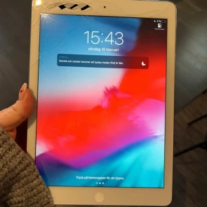 iPad med vit ram och silver baksida - Säljer en iPad A1474  med vit ram och silverfärgad baksida. Klassisk Apple-design med rund hemknapp och stor skärm. Perfekt för surf, appar och underhållning. Laddningsport och högtalare i nederkant.