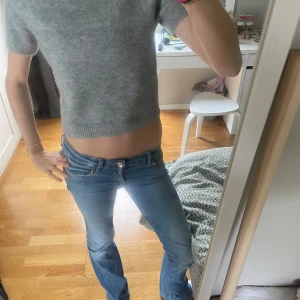 Grå stickad tröja från Zara - Säljer en grå stickad tröja från Zara med korta ärmar och rund hals. Tröjan har en mjuk och mysig känsla, perfekt för lager-på-lager och enkel att matcha med jeans eller kjol. Har ett litet hål på ryggen, inget man tänker på och går säkert att laga!