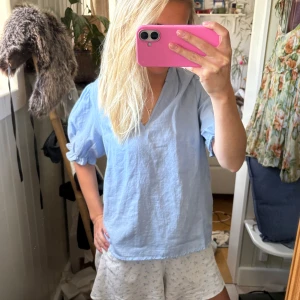 Ljusblå blus med puffärm - Säljer en ljusblå blus med v-ringning och puffiga, korta ärmar. Från Neo Noir. Passar till många tillfällen och så fin nu i sommar!Aldrig använd, prislappen kvar!🩵🩵