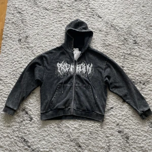 Svart hoodie YOURTURN - Säljer en svart hoodie från YOURTURN med vit grafisk text på bröstet. Tröjan har dragkedja, huva och fickor framtill. Materialet är mjukt och bekvämt, perfekt för en avslappnad stil. Helt ny, oanvänd.