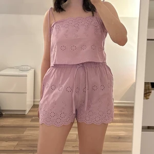 Ljuslila set från ASOS DESIGN - Säljer ett sött ljuslila set bestående av en topp i storlek 38 samt ett par shorts i storlek 34. Toppen har en rak passform med tunna axelband och broderade detaljer samt vågig kant nertill. Shortsen har snörning i midjan och även de broderade detaljer samt vågig kant nertill. De går även att styla var för sig, exempel på bild 2. Aldrig använda. 