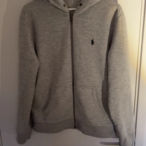 Grå och svart hoodie från Ralph Lauren - Två klassiska hoodies från Ralph Lauren, en i ljusgrått och en i svart. Kommer aldrig till användning, storlek M på båda, skriv för funderingar eller fler bilder