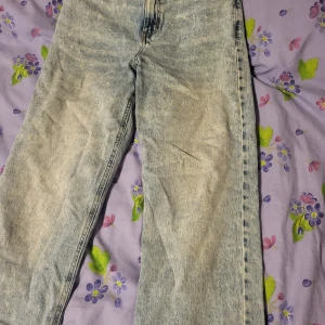 Ljusblå tvättade jeansbyxor med raka ben - Säljer ett par ljusblå jeansbyxor med stentvättad look och raka ben. Klassisk femficksmodell med knapp och dragkedja framtill. Jeansen har en avslappnad passform och är perfekta för en chill stil.