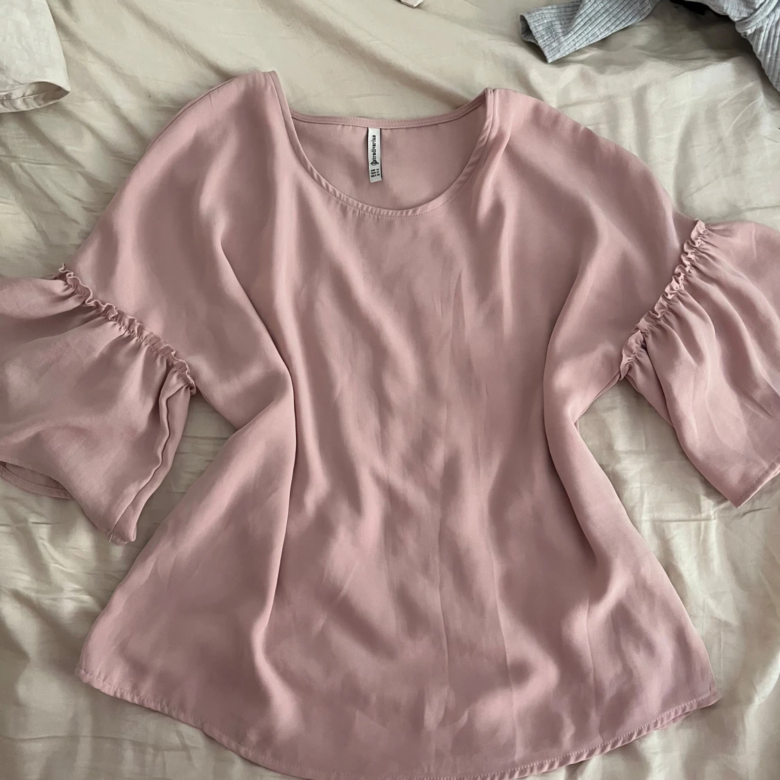 Ljusrosa blus med volangärmar 