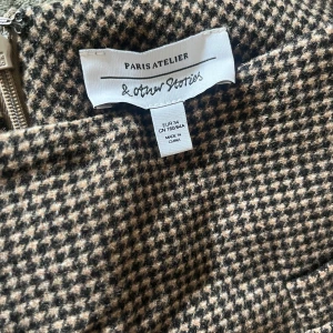 Rutig minikjol från & Other Stories - Säljer en snygg rutig minikjol i ull från & Other Stories Paris Atelier i storlek 34. 